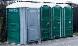 porta potties in a line next to a dirt path